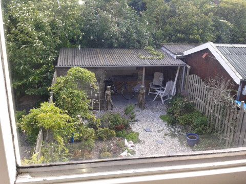 hier is tuin nog niet afgescheiden voor de boven bewoners. Het afdak is tevens de berging voor de fiets/brommer